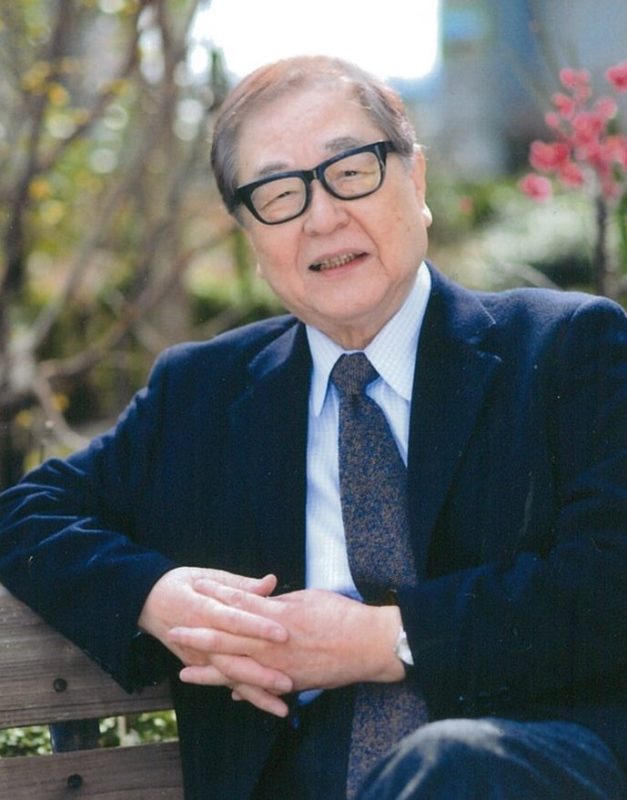 山川静夫さんのお写真です。黒縁メガネをかけて、にっこりと微笑んでいる優しげなお顔立ちをしています。
