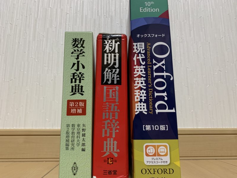 左から数学小辞典の辞書、新明解の辞書、Oxfordの辞書の順に立てかけられている。